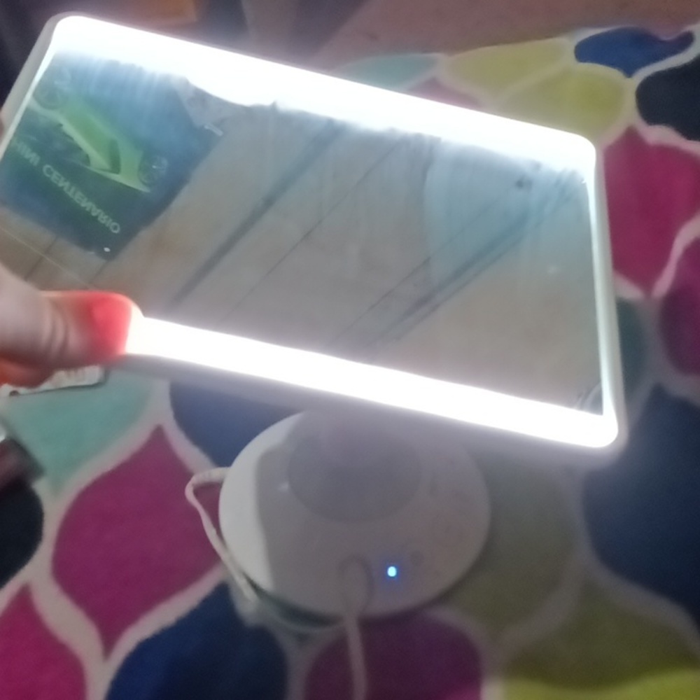 A mirror with side lights a adjustable stand and the stand is Blue tooth